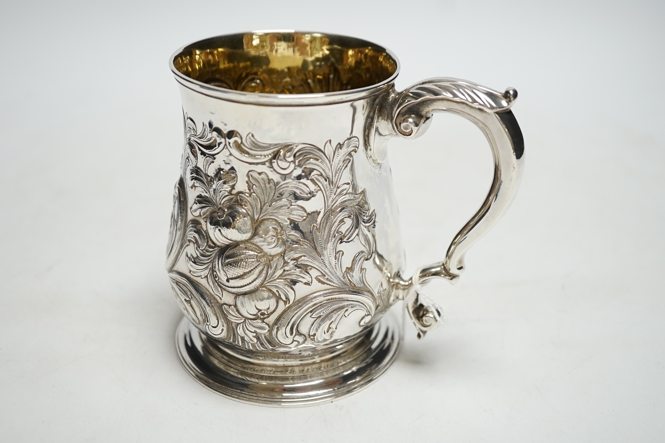 A George II silver pint mug, by John Broughton?, London, 1746, with later embossed decoration and later engraved inscription, 11.8cm, 10.7oz.